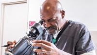 A researcher using a microscope